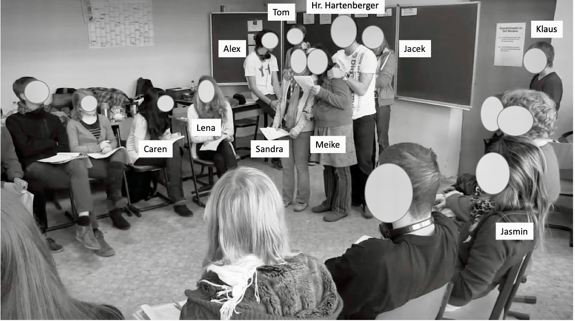 Photo der Rollenspielsituation mit allen Schüler:innen mit Meike und Sandra im Zentrum